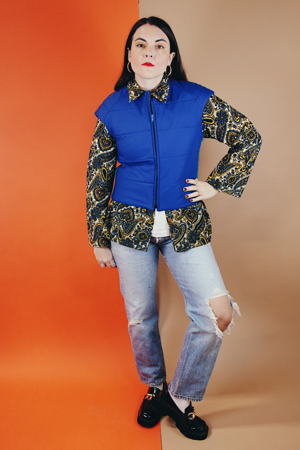 Women's vintage medium 1980's SKYR by Hertha Amen label sleeveless capped sleeved short length zip up bright blue Nylon ski vest with red and green stripes on the sides.