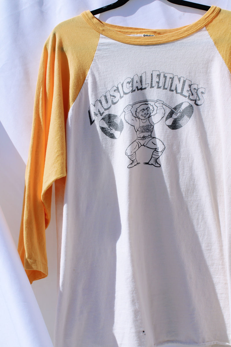 long sleeve vintage baseball tee cream body with yellow arms 1976 tower records graphic on front and back