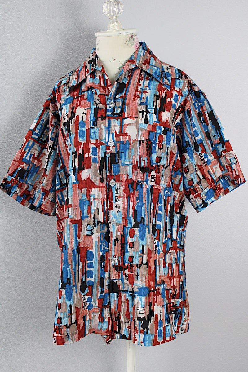 Men's or women's vintage 1970's Joel California label short sleeve button up shirt with a pointy collar. Lightweight polyester material in blue, grey, black, and salmon colored abstract print. 
