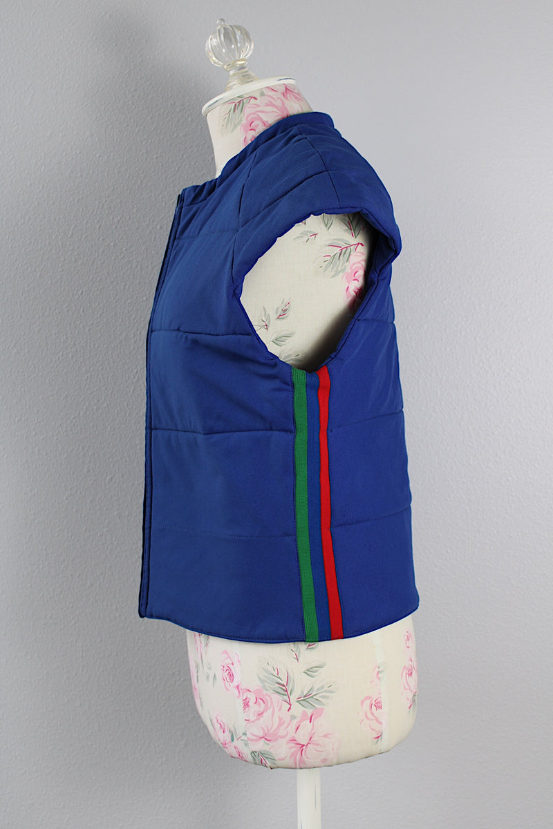 Women's vintage medium 1980's SKYR by Hertha Amen label sleeveless capped sleeved short length zip up bright blue Nylon ski vest with red and green stripes on the sides.