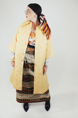 gold colored quilted duster jacket buttons up the front with collar and moon and star all over print