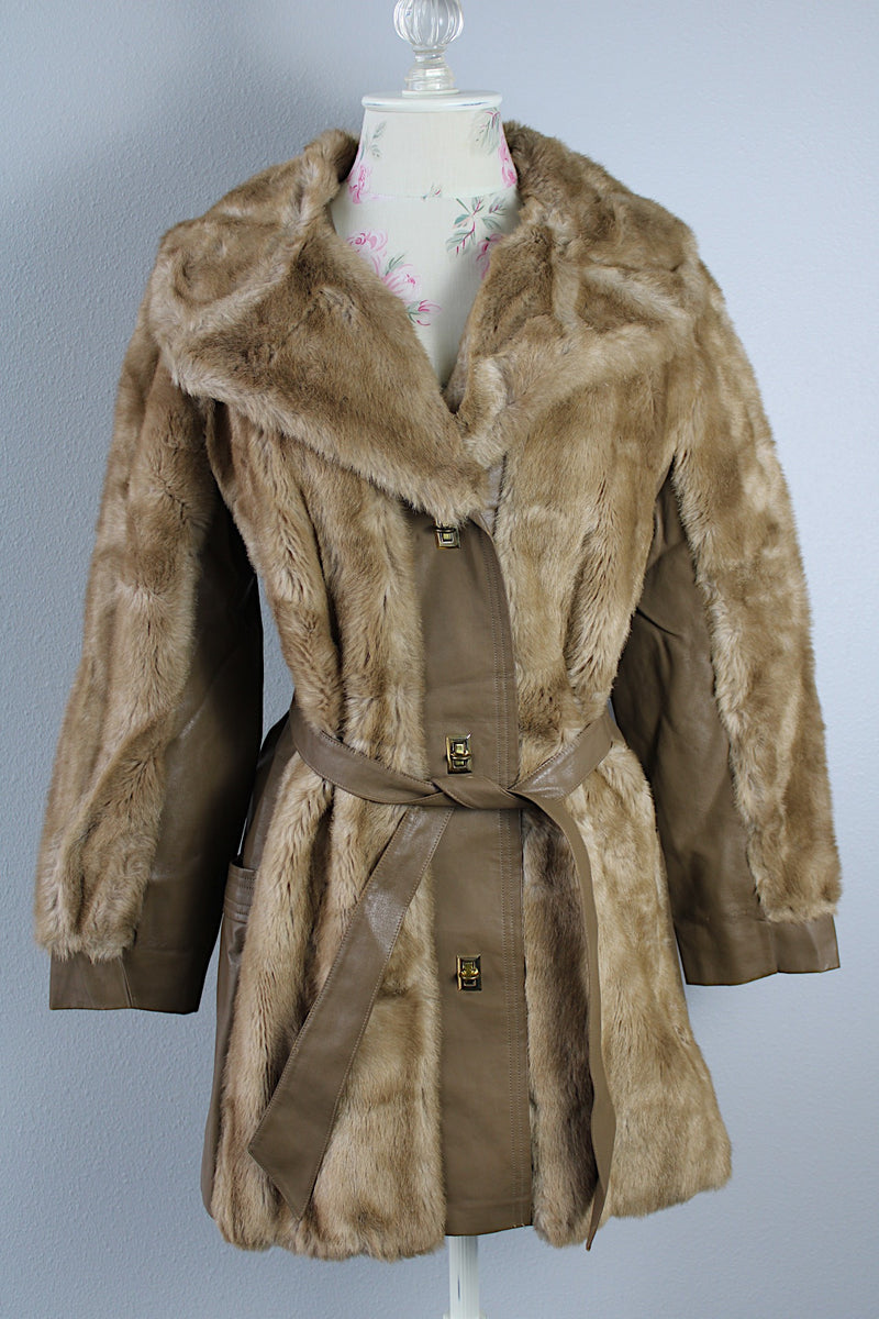 Women's vintage 1960's long sleeve knee length faux fur tan coat with leather trim. Has a matching leather belt, gold twist buttons, and pockets