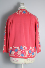 Women's vintage 1950's Gene Shelly's Miss Boutique California label 3/4 arm length open front pink cardigan sweater in wool material with blue, white, and pink embroidered flowers all over