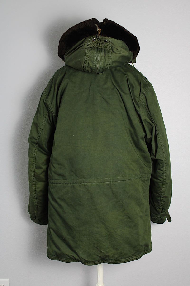 Men's vintage 1940's Army B-940 parka coat in arm green color, cotton material with nylon quilted. Faux fur hooded detachable hood, zipper and buttons closure up the front. 