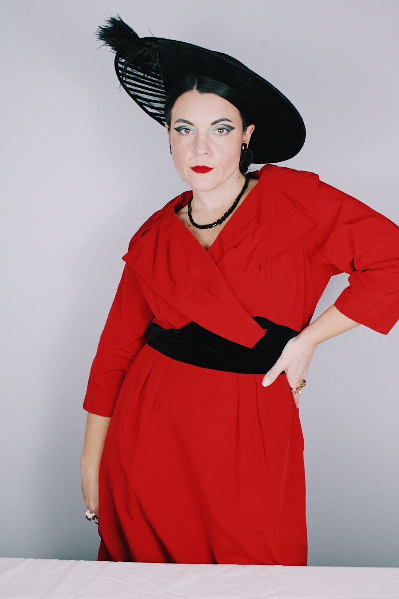Women's vintage 1950's Jr. Plenty Shop, Lane Bryant label 3/4 arm length midi length red dress with V shaped neckline, black velvet waistband and double lapel collar.