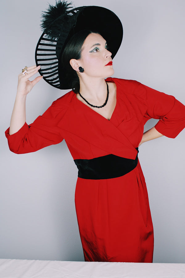 Women's vintage 1950's Jr. Plenty Shop, Lane Bryant label 3/4 arm length midi length red dress with V shaped neckline, black velvet waistband and double lapel collar.