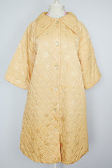 gold colored quilted duster jacket buttons up the front with collar and moon and star all over print