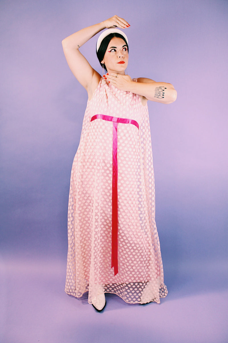 sleeveless pink dress with polka dot sheer lace overlay and ribbon around waist vintage 1960's