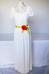 Women's vintage 1970's short sleeve maxi length white dress with tiered lace ruffles all over and an attached yellow belt with flowers