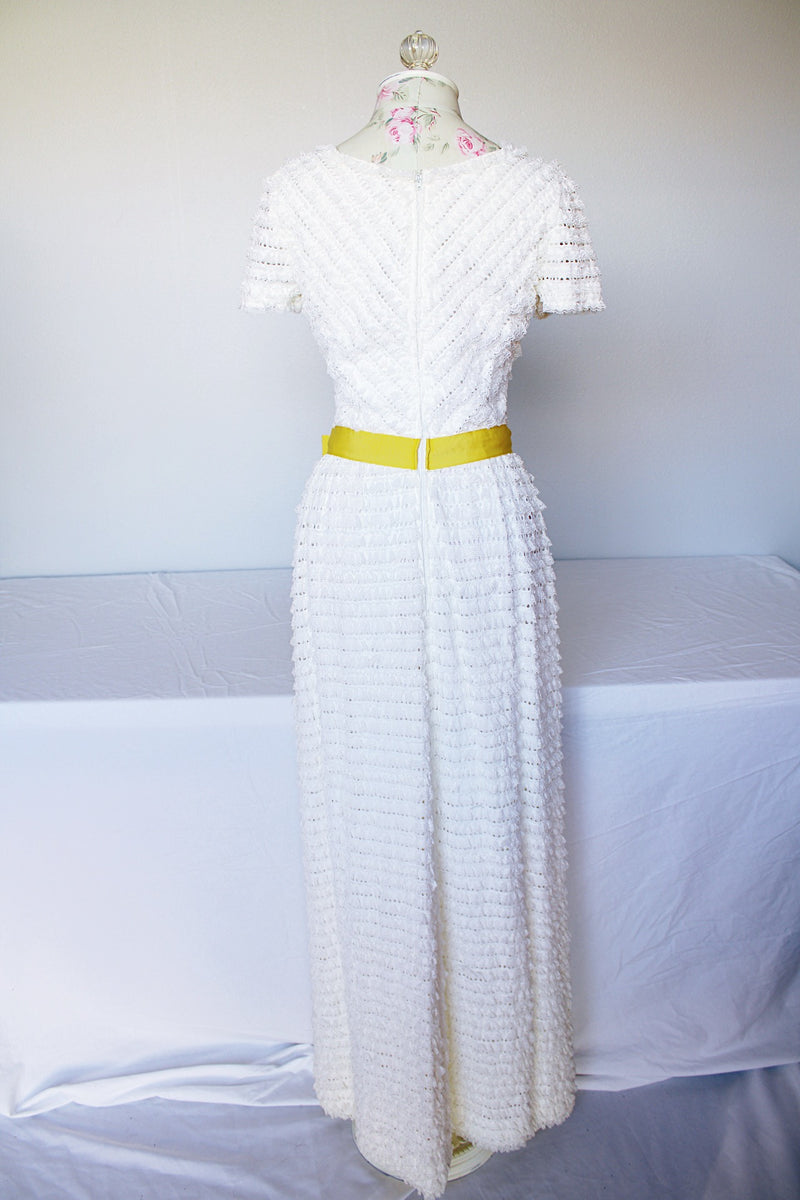 Women's vintage 1970's short sleeve maxi length white dress with tiered lace ruffles all over and an attached yellow belt with flowers