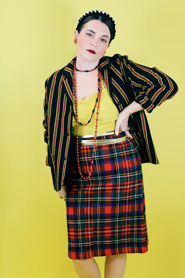 Women's vintage 1970's knee length pencil skirt in an acrylic material in red, blue, yellow, and white all over tartan plaid print.