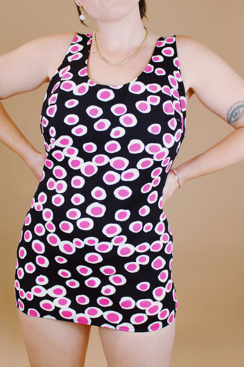 vintage 1960's one piece swimsuit in black with white and pink polka dots skirt in front over bottoms 
