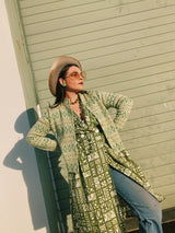 Women's vintage 1960's short sleeve midi length green and white printed wrap dress with two big white buttons at waist.