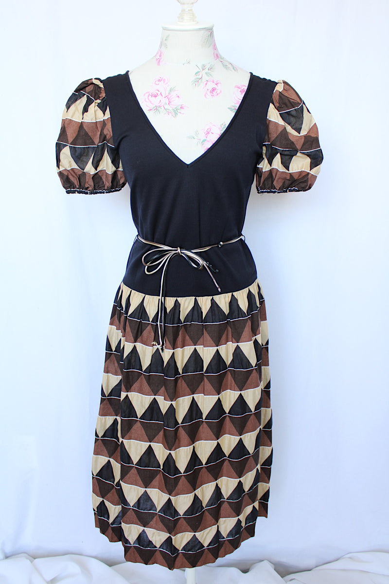 Women's vintage 1970's short sleeve puff sleeve midi length dress in cotton material. Black body with brown and tan printed sleeves and skirt.
