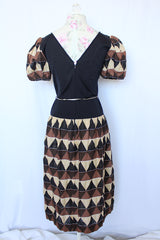 Women's vintage 1970's short sleeve puff sleeve midi length dress in cotton material. Black body with brown and tan printed sleeves and skirt.