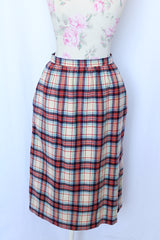 Women's vintage 1970's Weathervane label knee length pencil skirt in wool material, fully lined, cream color with red, navy, and blue plaid print.