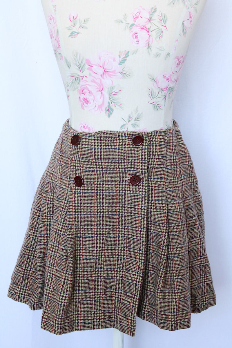 Women's vintage and retro 1990's Limited, Made in Italy label mini skirt in brown plaid print with a wrap front closure and four brown buttons.