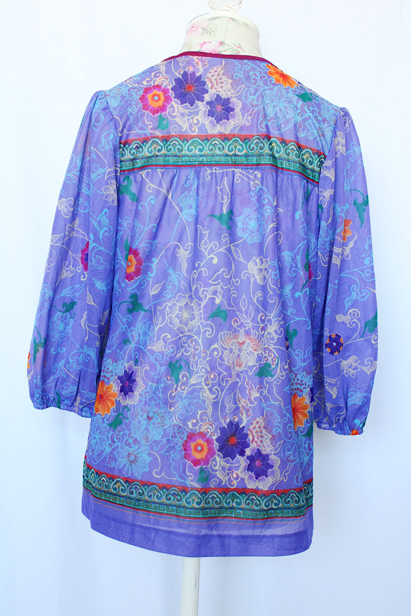 Women's vintage 1970's That's It! California label 3/4 arm length purple sheer lightweight polyester material pullover blouse in purple with all over floral print.