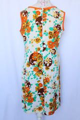 Women's vintage 1960's sleeveless knee length shift dress in off white with an all over floral print and orange trim.