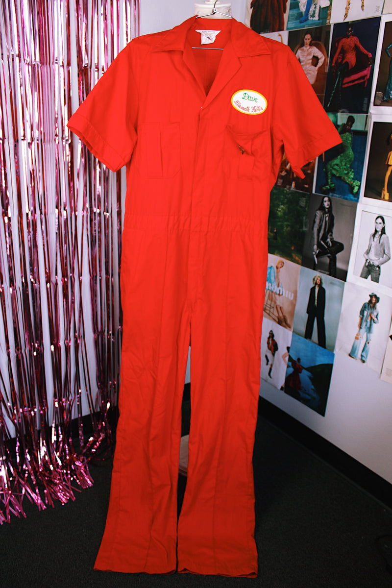 short sleeve red work jumpsuit with collar zips up front and patches on front and back vintage 1970's