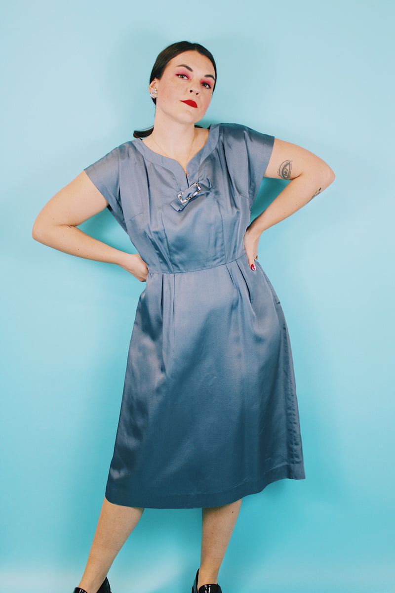 Women's vintage 1950's Martha Manning Original short sleeve capped sleeved midi length light blue dress with V shaped neckline with a bow and rhinestone broach attached at neck.