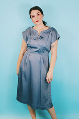 Women's vintage 1950's Martha Manning Original short sleeve capped sleeved midi length light blue dress with V shaped neckline with a bow and rhinestone broach attached at neck.