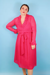 Women's vintage 1970's long sleeve midi length bright pink sheer dress with half button closure and ruffle trim around neckline and cuffs. 