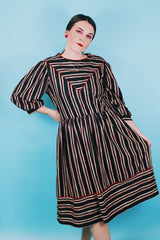 Women's vintage 1980's Walden Classics, Made in USA label 3/4 arm length midi length black striped dress with cinched waist, buttons on shoulders and triangle flap in front and back.