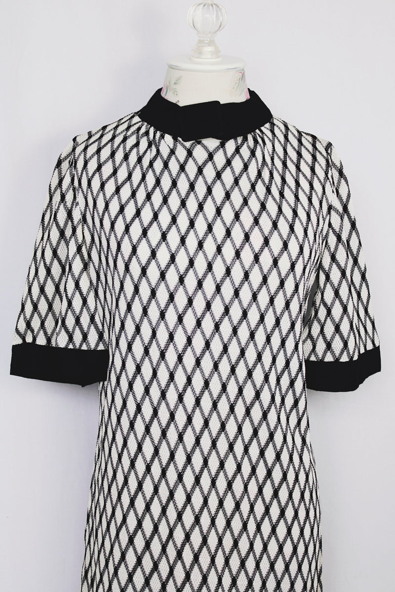 Women's vintage 1970's Mode O'Day, Styled in California label short sleeve mini length dress in black and white polyester material with diamond checkered print. 