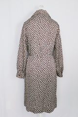 Women's vintage 1970's long sleeve knee length button up shirt dress in brown with all over white floral print. 