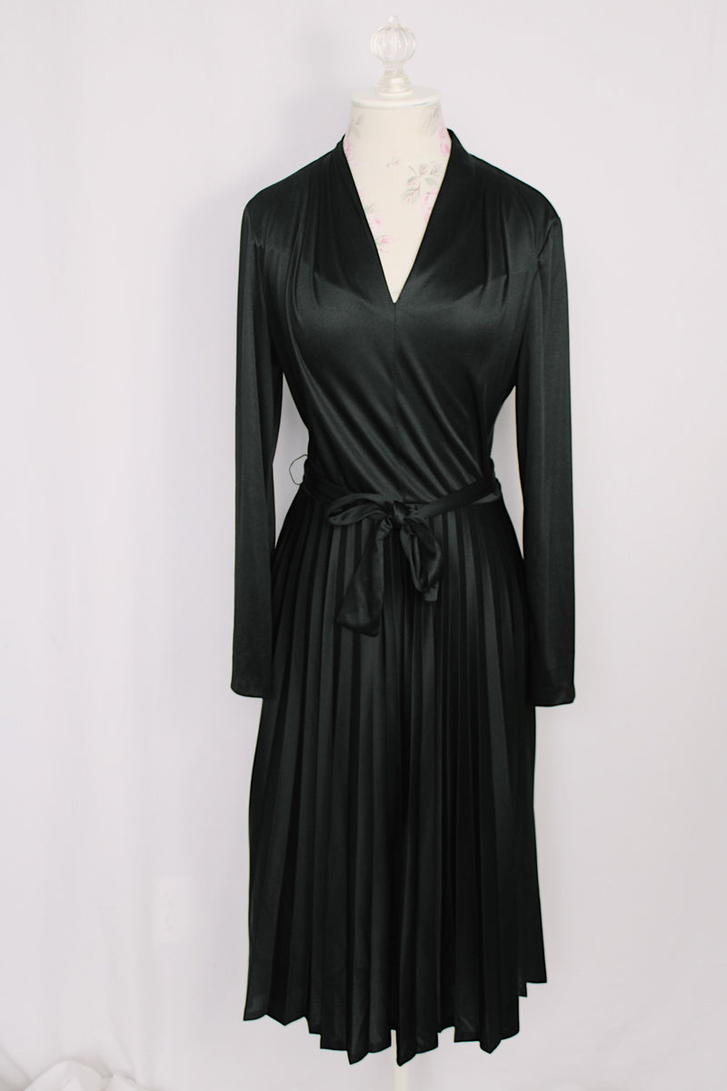  Women's vintage 1970's Joan Curtis long sleeve midi length black dress with pleated accordion skirt, a V shaped neckline, and detachable matching tie belt. 