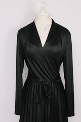 Women's vintage 1970's Joan Curtis long sleeve midi length black dress with pleated accordion skirt, a V shaped neckline, and detachable matching tie belt. 