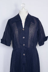Women's vintage 1950's short sleeve midi length navy blue sheer shirt dress with subtle checkered print.