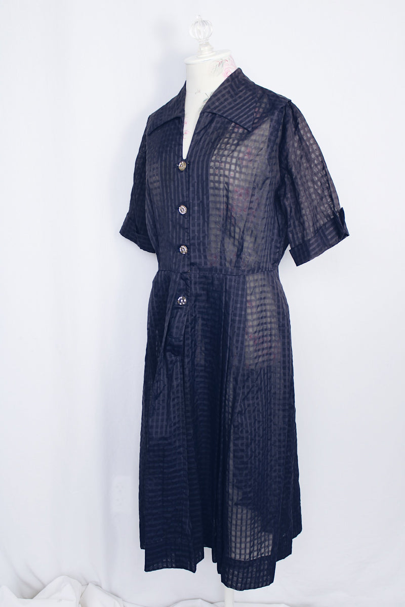 Women's vintage 1950's short sleeve midi length navy blue sheer shirt dress with subtle checkered print.