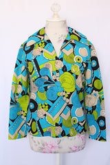 Women's vintage 1970's long sleeve collared blouse with zipper in the back and V shaped neckline. Polyester material in green and blue all over print.