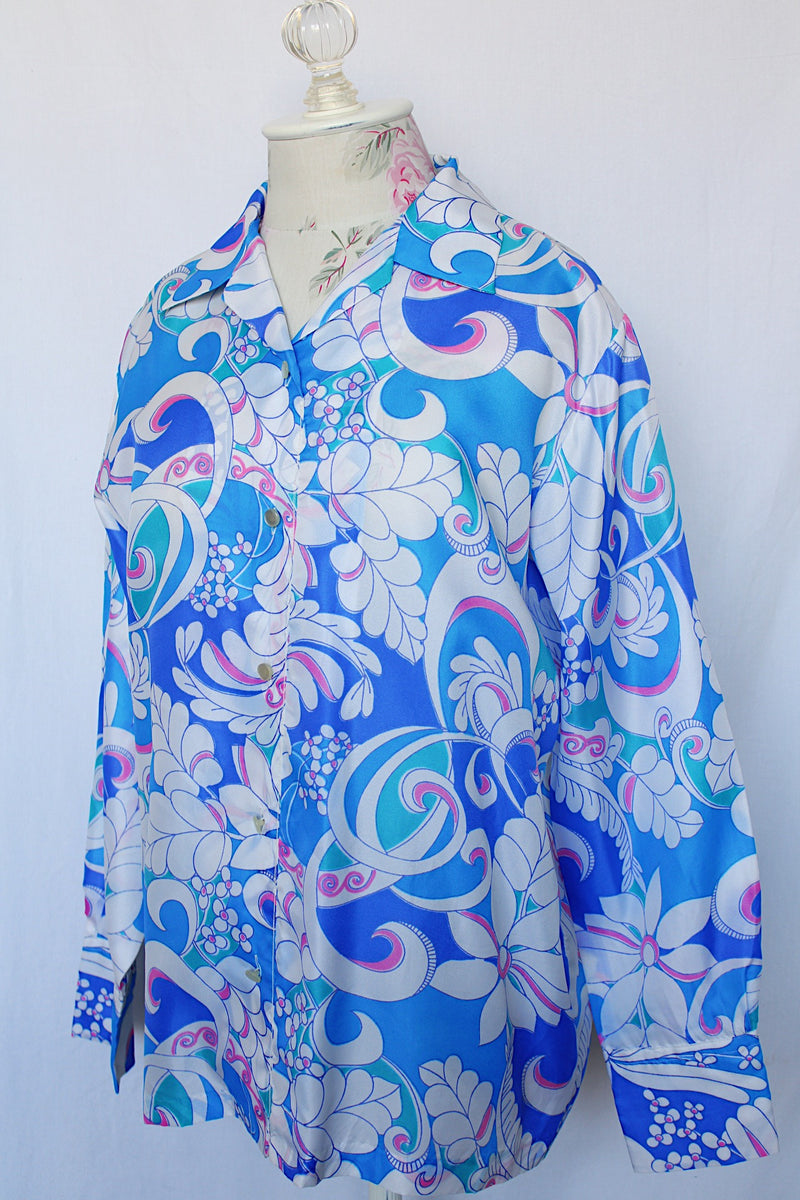 Women's vintage 1970's long sleeve all over print collared blouse in blue, white, and pink print.