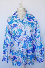 Women's vintage 1970's long sleeve all over print collared blouse in blue, white, and pink print.