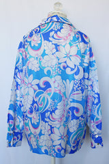 Women's vintage 1970's long sleeve all over print collared blouse in blue, white, and pink print.