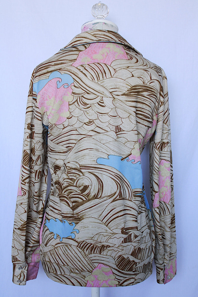 Women's vintage 1970's long sleeve button up blouse with pointy collar in thick polyester. Brown abstract print with pops of baby blue and pink. 