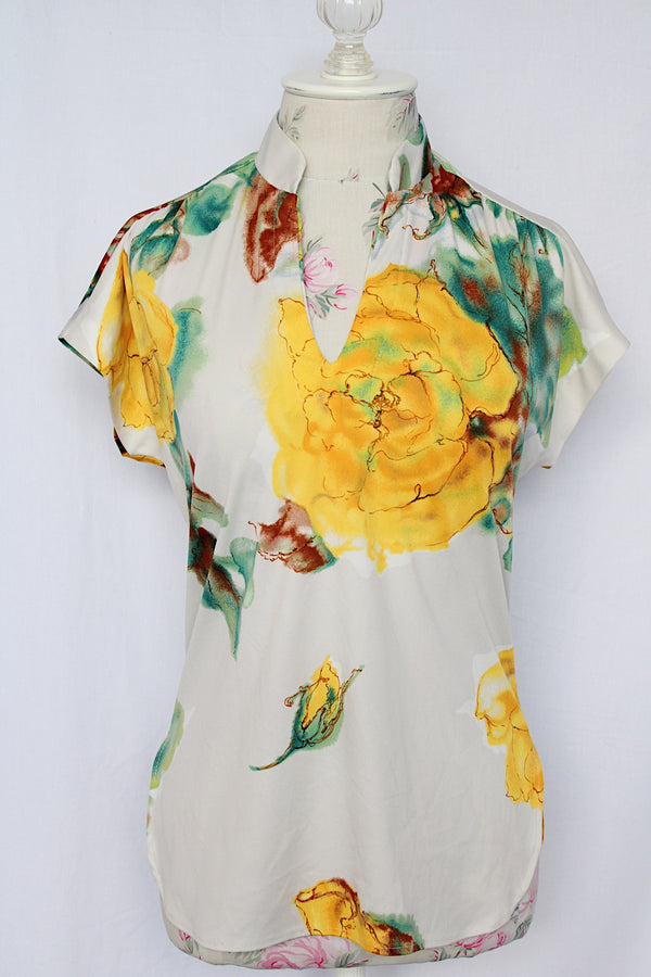 Women's vintage 1970's short sleeve white polyester blouse with all over yellow and green floral print.