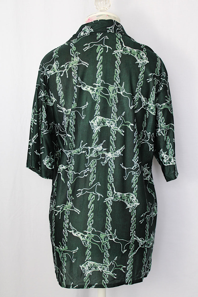 Women's or men's vintage 1970's short sleeve slinky polyester button up shirt with dagger collar and green all over horse and buffalo print.
