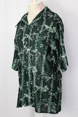 Women's or men's vintage 1970's short sleeve slinky polyester button up shirt with dagger collar and green all over horse and buffalo print.