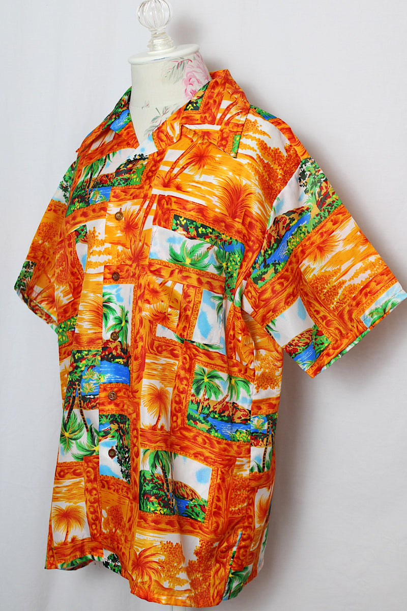 Men's or women's vintage 1970's Mauna Kea label short sleeve button up shirt with double lapel, left chest pocket, and amber buttons in orange all over Hawaiian print. 