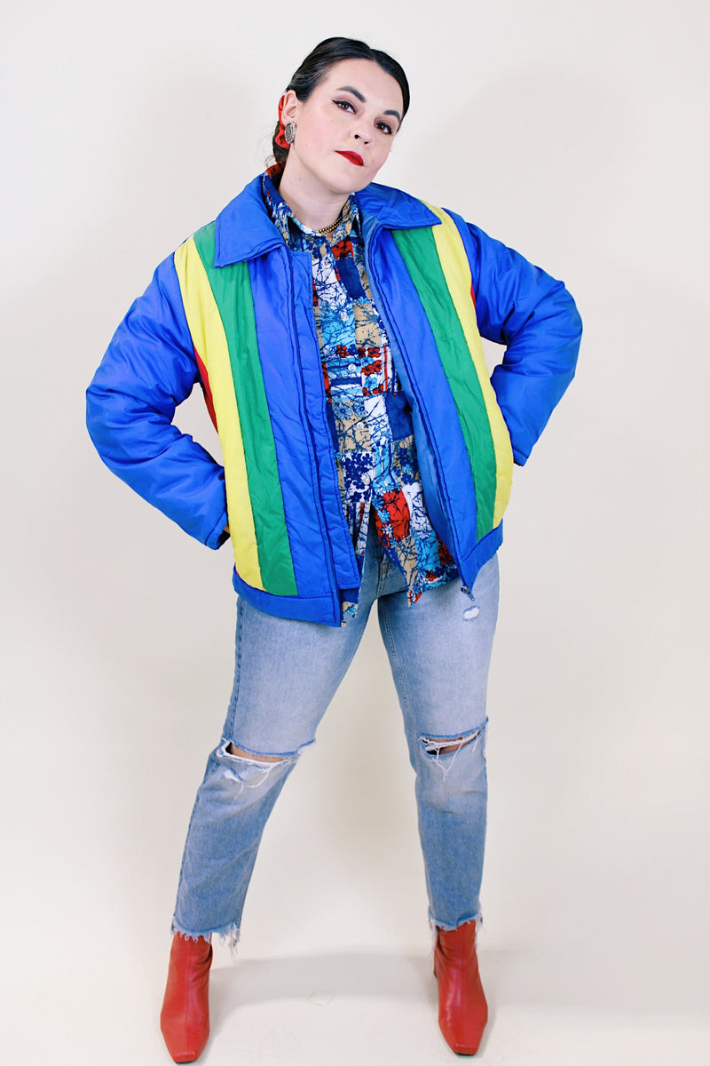 Women's or men's vintage 1970's Montgomery Ward Custom Outerwear label long sleeve ski jacket in blue with yellow, red, and green stripes in the front.