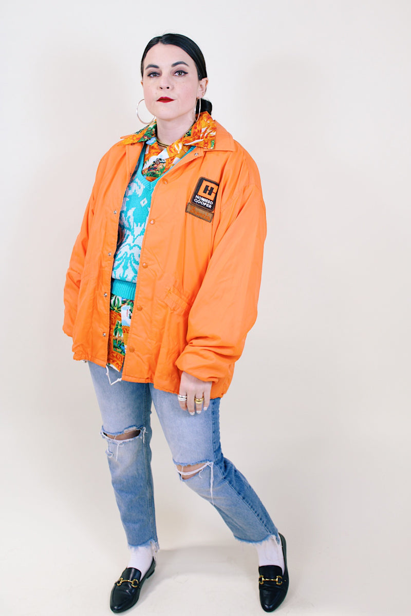 Men's or women's vintage 1970's Pla-Jac by Dunbrooke label long sleeve orange lightweight windbreaker with two patches on left chest.