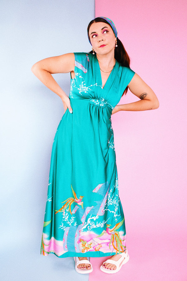 sleeveless maxi length turquoise dress with floral and bird print around hem vintage 1970's
