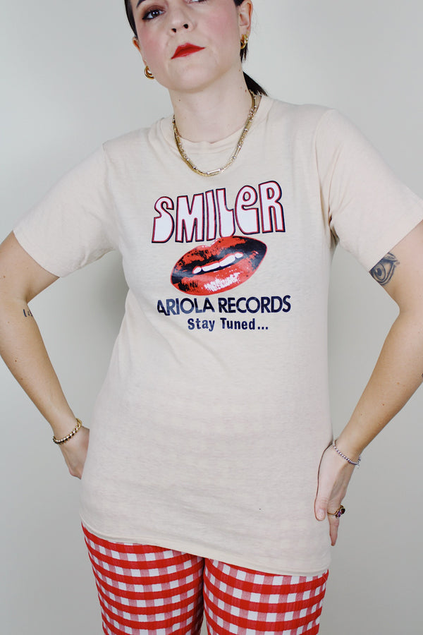short sleeve light tan cotton t-shirt with Smiler Ariola Records graphic on the front 1970's