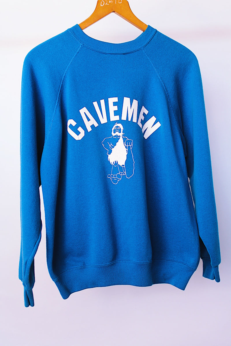 long sleeve blue crew neck sweater with cavemen graphic vintage 1970's