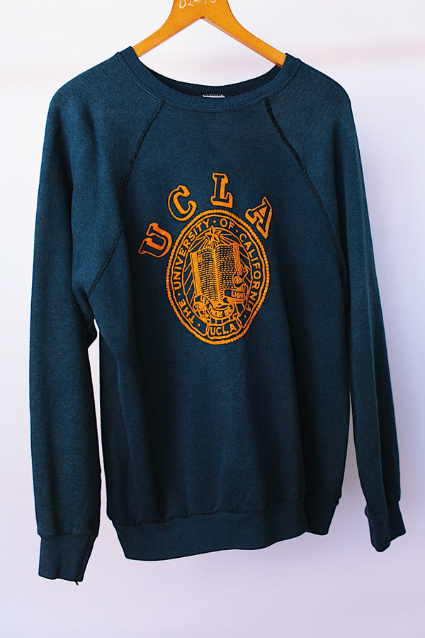 long sleeve navy crew neck sweater with yellow felt UCL logo on front vintage 1970's