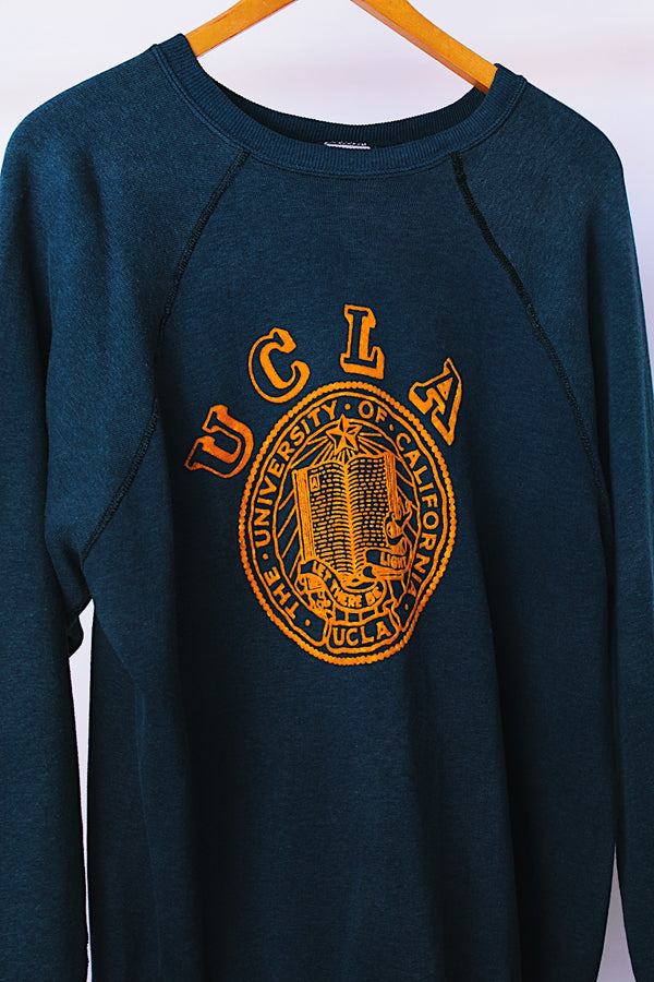 long sleeve navy crew neck sweater with yellow felt UCL logo on front vintage 1970's